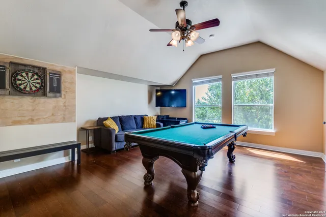 a room with pool table and windows