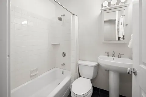 a bathroom with a toilet sink shower and mirror