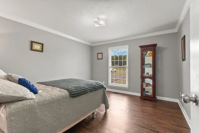 a bedroom with a bed and wooden floor