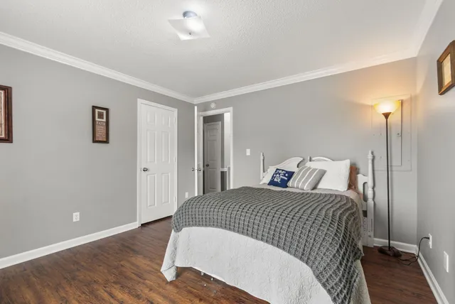 a bedroom with a bed and wooden floor