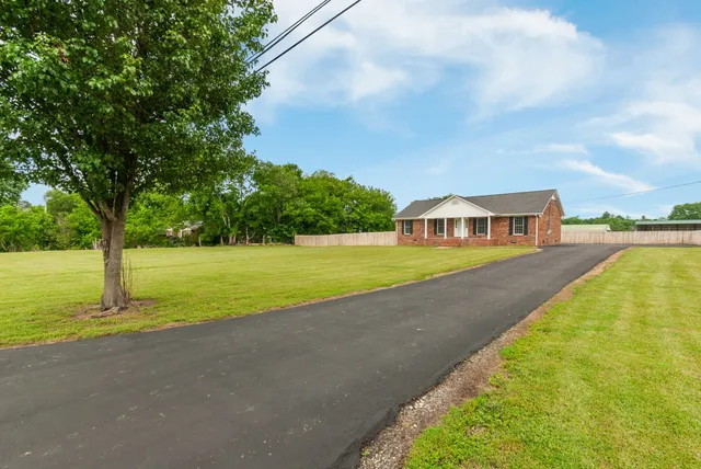 a view of a house with swimming pool and yard