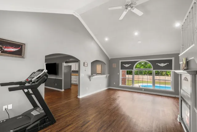 a view of an empty room with wooden floor and windows