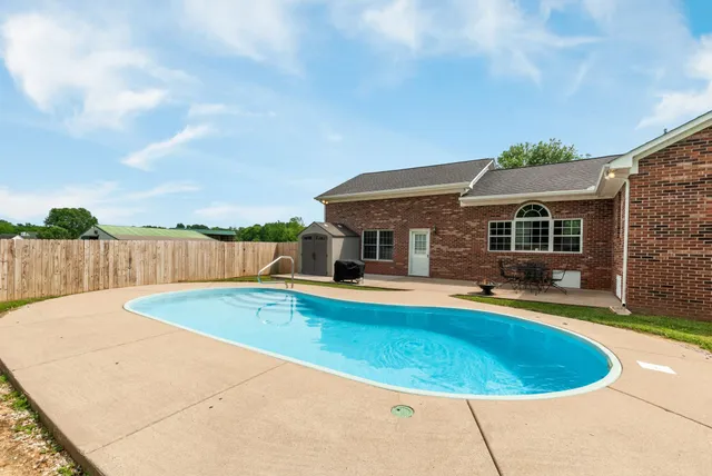 a view of a house with pool fire pit and furniture