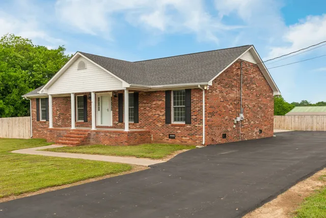 a front view of a house with a garden and yard