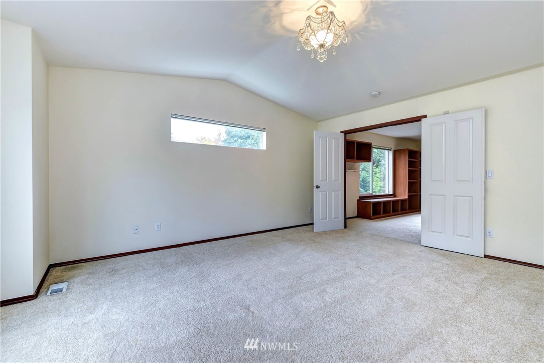 1031 215th Place Southeast Bothell, WA 98021 - Photo 17 of 25 an empty room with a chandelier fan and windows