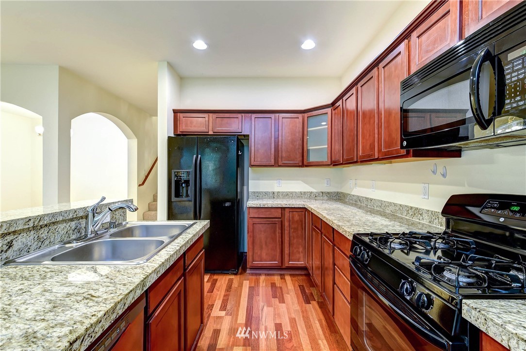 1031 215th Place Southeast Bothell, WA 98021 - Photo 10 of 25 a kitchen with stainless steel appliances granite countertop a sink stove and refrigerator