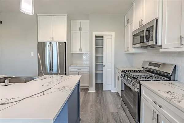 a kitchen with stainless steel appliances kitchen island a stove microwave and refrigerator