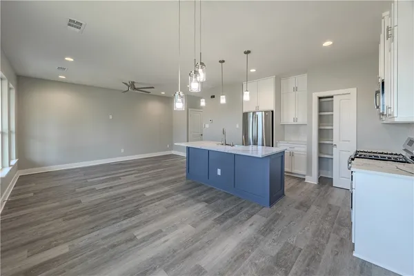 a kitchen with stainless steel appliances kitchen island a cabinets and wooden floor