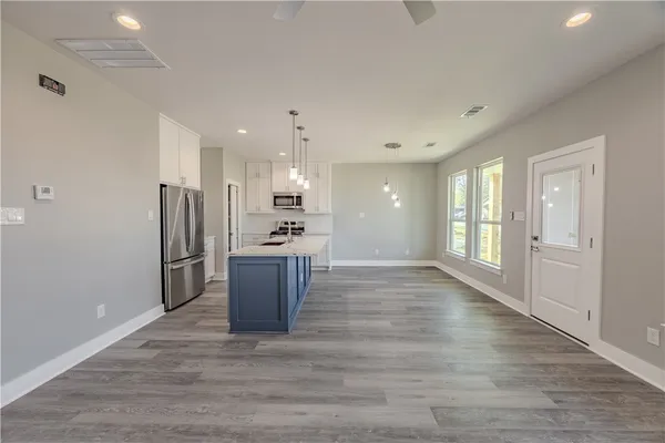 a large kitchen with a refrigerator and a stove top oven