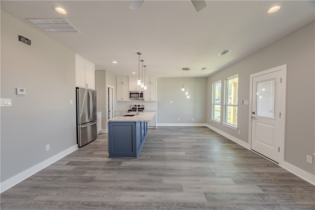 729 Ebenezer Lane Brenham, TX 77833 - Photo 2 of 25 a large kitchen with a refrigerator and a stove top oven