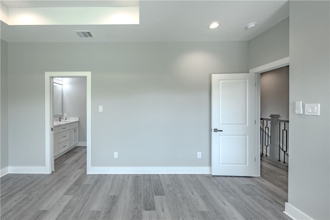 729 Ebenezer Lane Brenham, TX 77833 - Photo 4 of 25 a view of an empty room with wooden floor and a bathroom