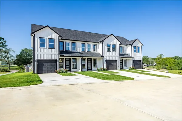 a front view of a house with a yard and garage