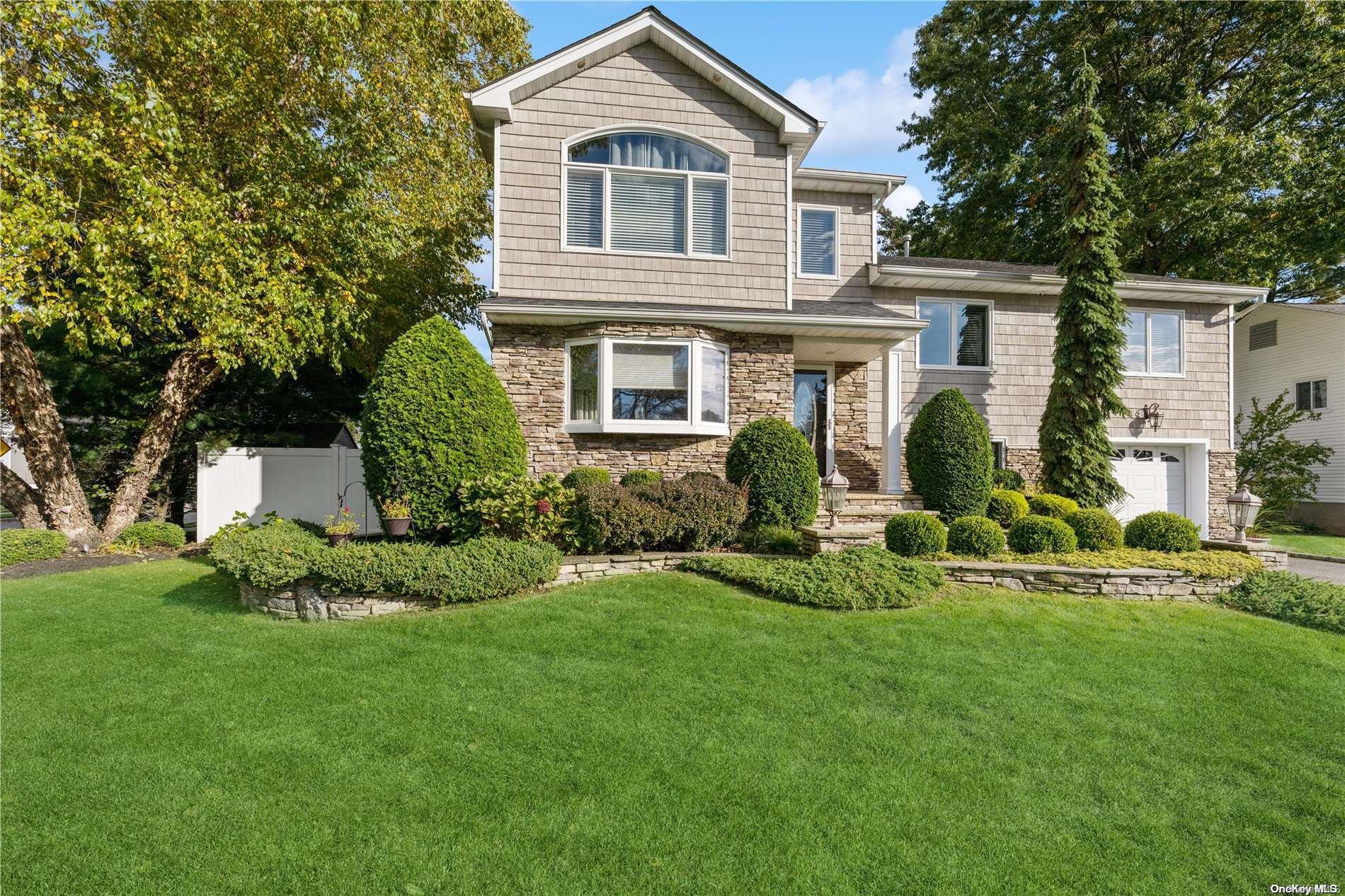 a front view of a house with a yard and potted plants