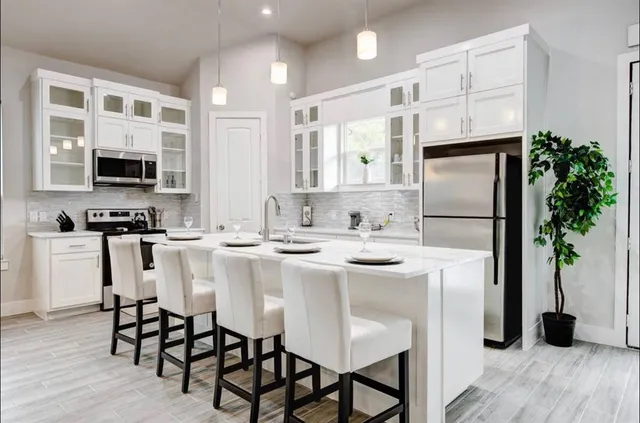a kitchen with stainless steel appliances a sink a table and chairs