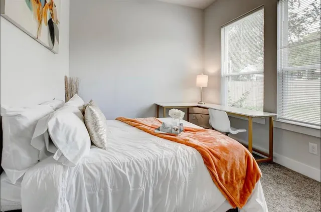 a bedroom with a bed and a large window