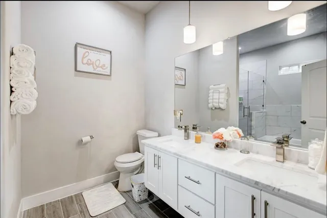 a bathroom with a double vanity sink toilet and a mirror
