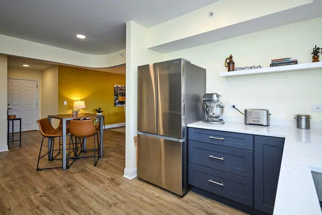 a kitchen with stainless steel appliances granite countertop a refrigerator and a stove top oven