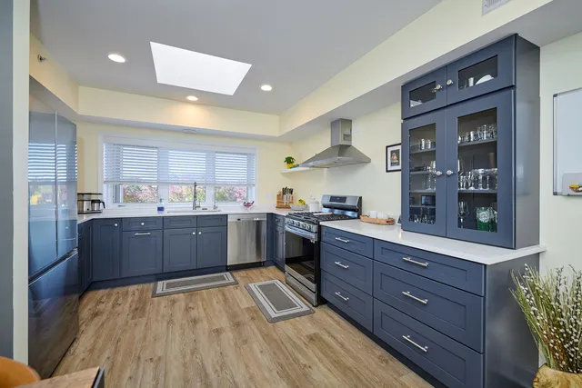 a kitchen with stainless steel appliances granite countertop wooden cabinets and counter top space