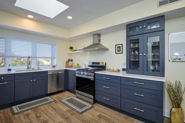 a kitchen with stainless steel appliances granite countertop wooden cabinets and a stove top oven
