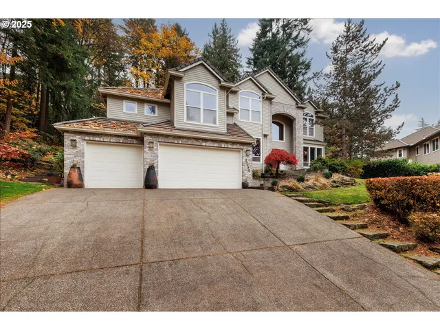 a view of a white house with a yard and garage