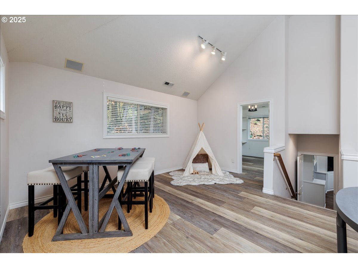 15540 Southwest Baker Lane Portland, OR 97224 - Photo 26 of 43 a view of dining room and livingroom with furniture wooden floor a rug a painting and a chandelier