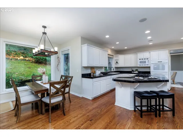 a kitchen with kitchen island a dining table and chairs