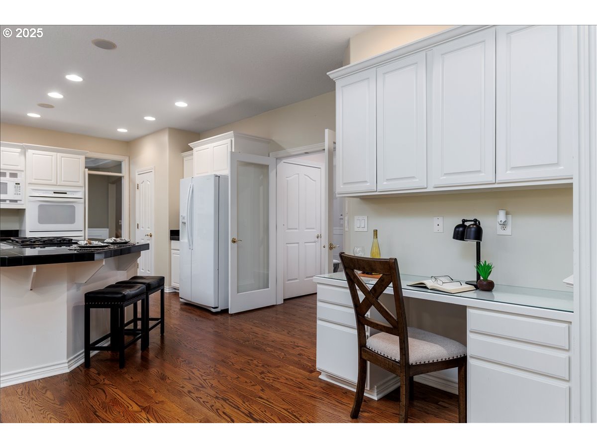 15540 Southwest Baker Lane Portland, OR 97224 - Photo 7 of 43 a kitchen with stainless steel appliances granite countertop a table chairs and a refrigerator