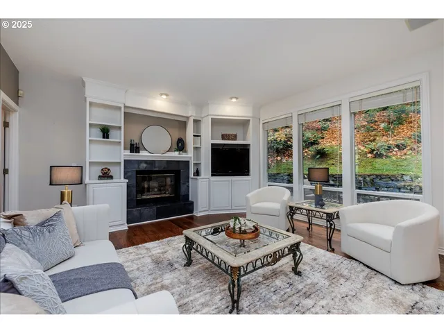 a living room with furniture a large window and a fireplace