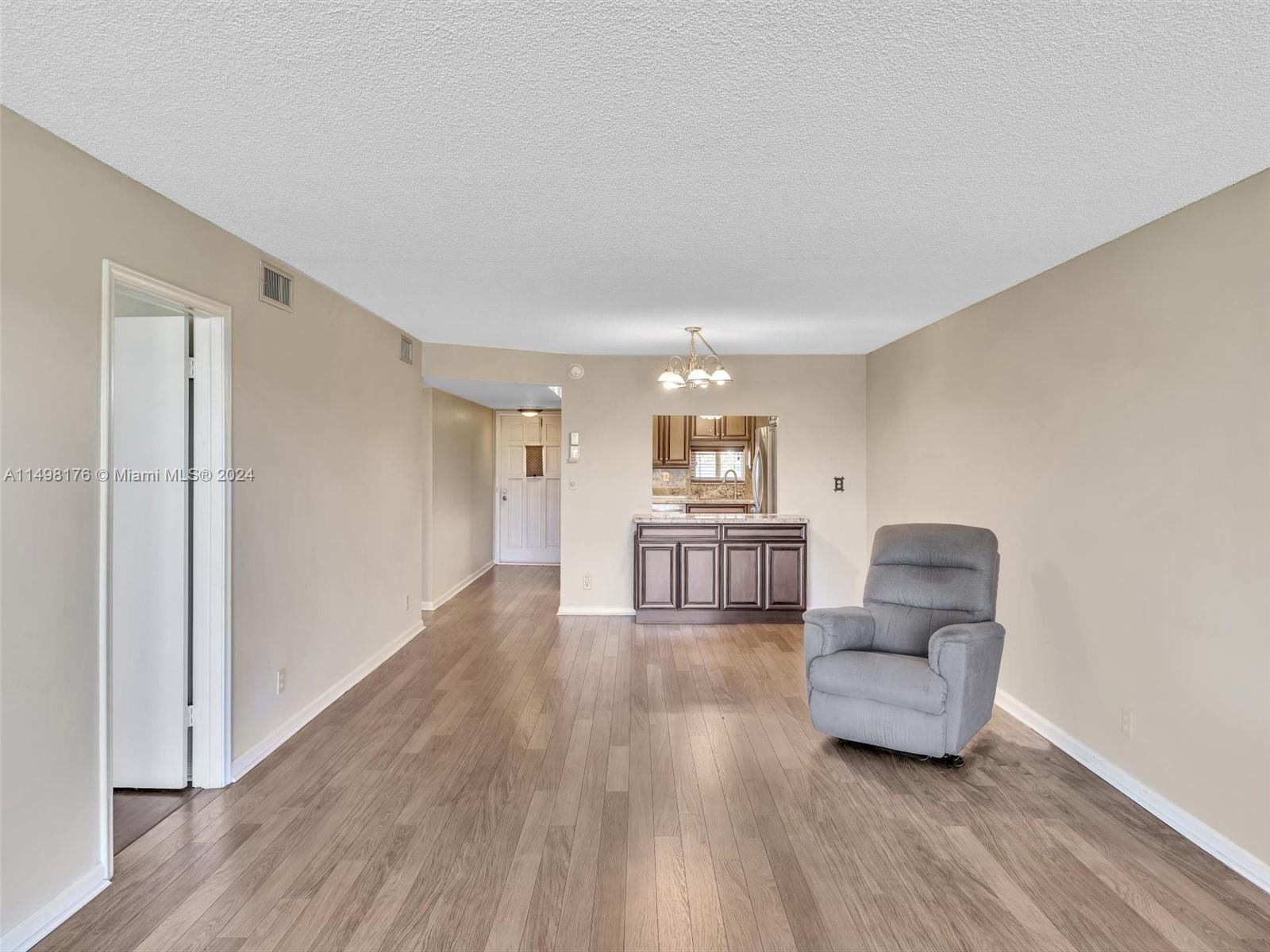 9411 North Hollybrook Lake Drive, Unit 209 Pembroke Pines, FL 33025 - Photo 19 of 36 a living room with furniture and a wooden floor
