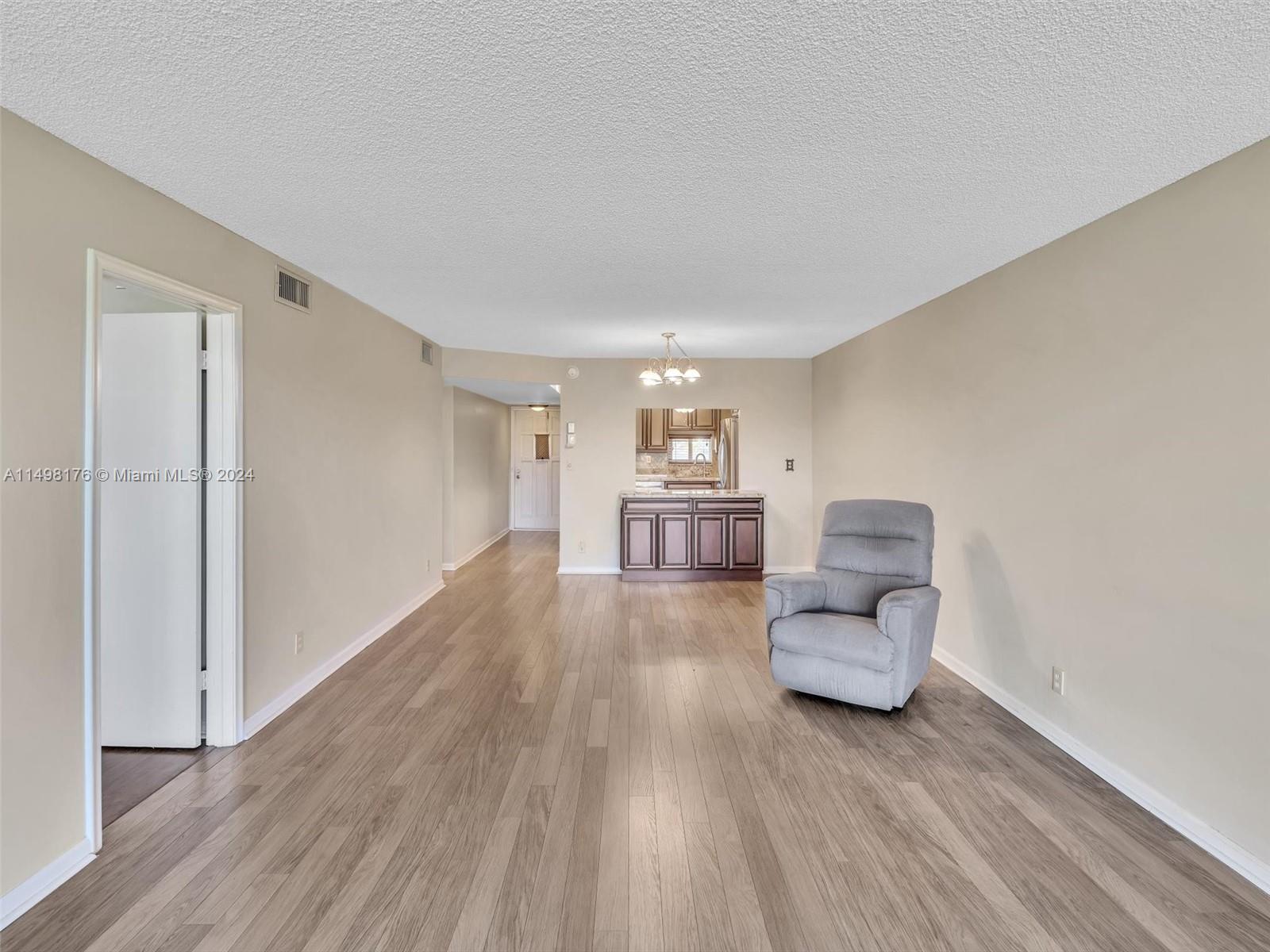 9411 North Hollybrook Lake Drive, Unit 209 Pembroke Pines, FL 33025 - Photo 20 of 36 a living room with furniture and a wooden floor