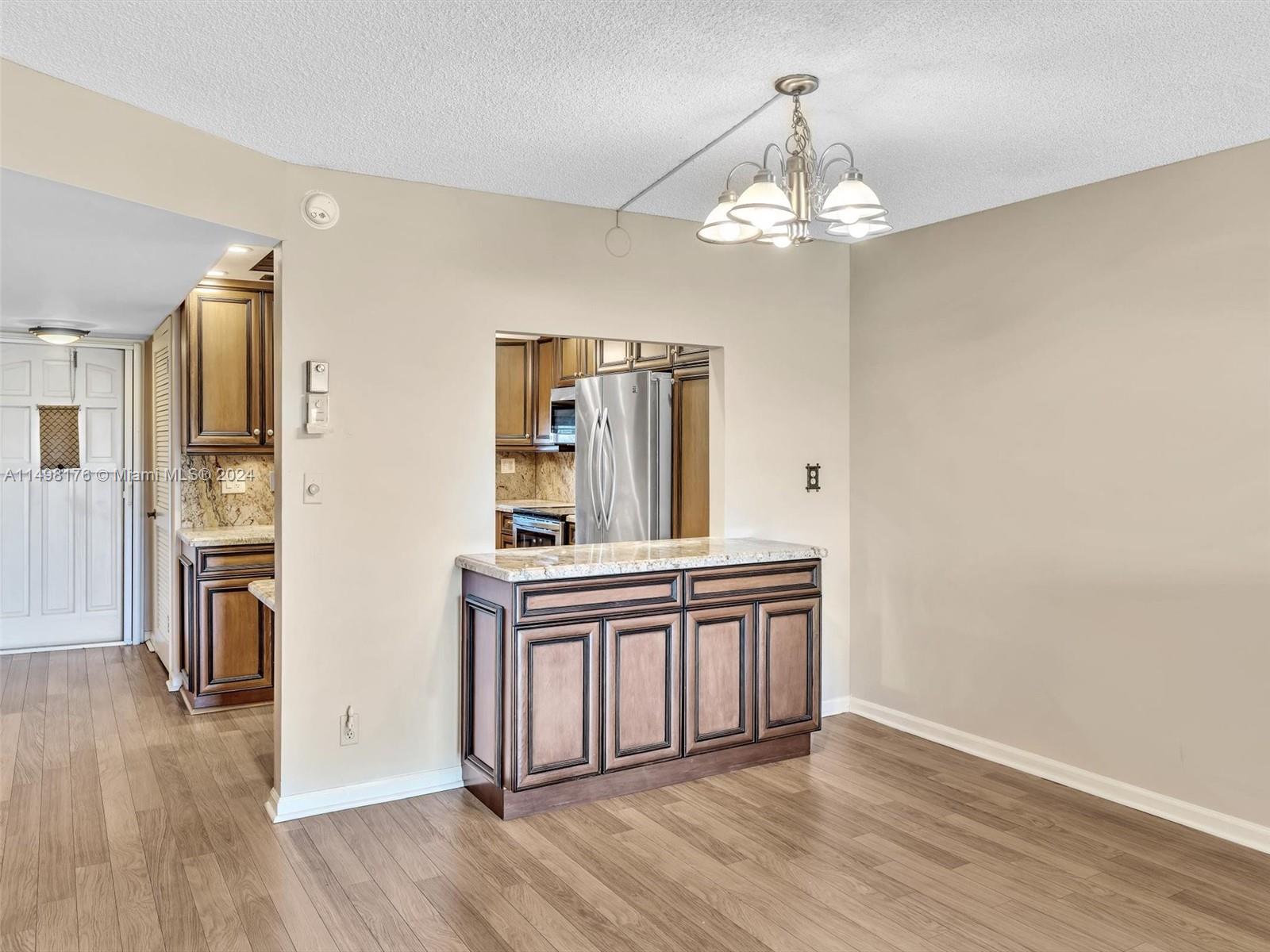 9411 North Hollybrook Lake Drive, Unit 209 Pembroke Pines, FL 33025 - Photo 21 of 36 a view of a kitchen with wooden floor and stainless steel appliances