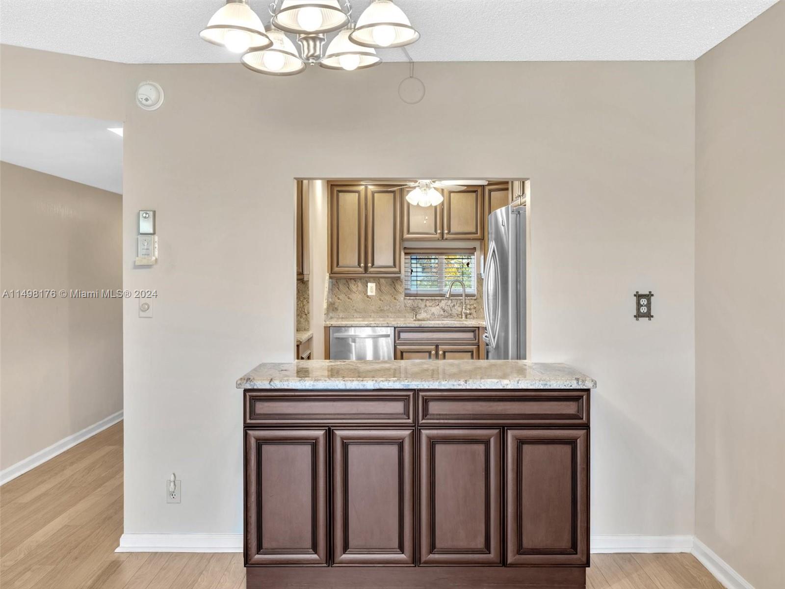 9411 North Hollybrook Lake Drive, Unit 209 Pembroke Pines, FL 33025 - Photo 22 of 36 a kitchen with a sink a window and cabinets
