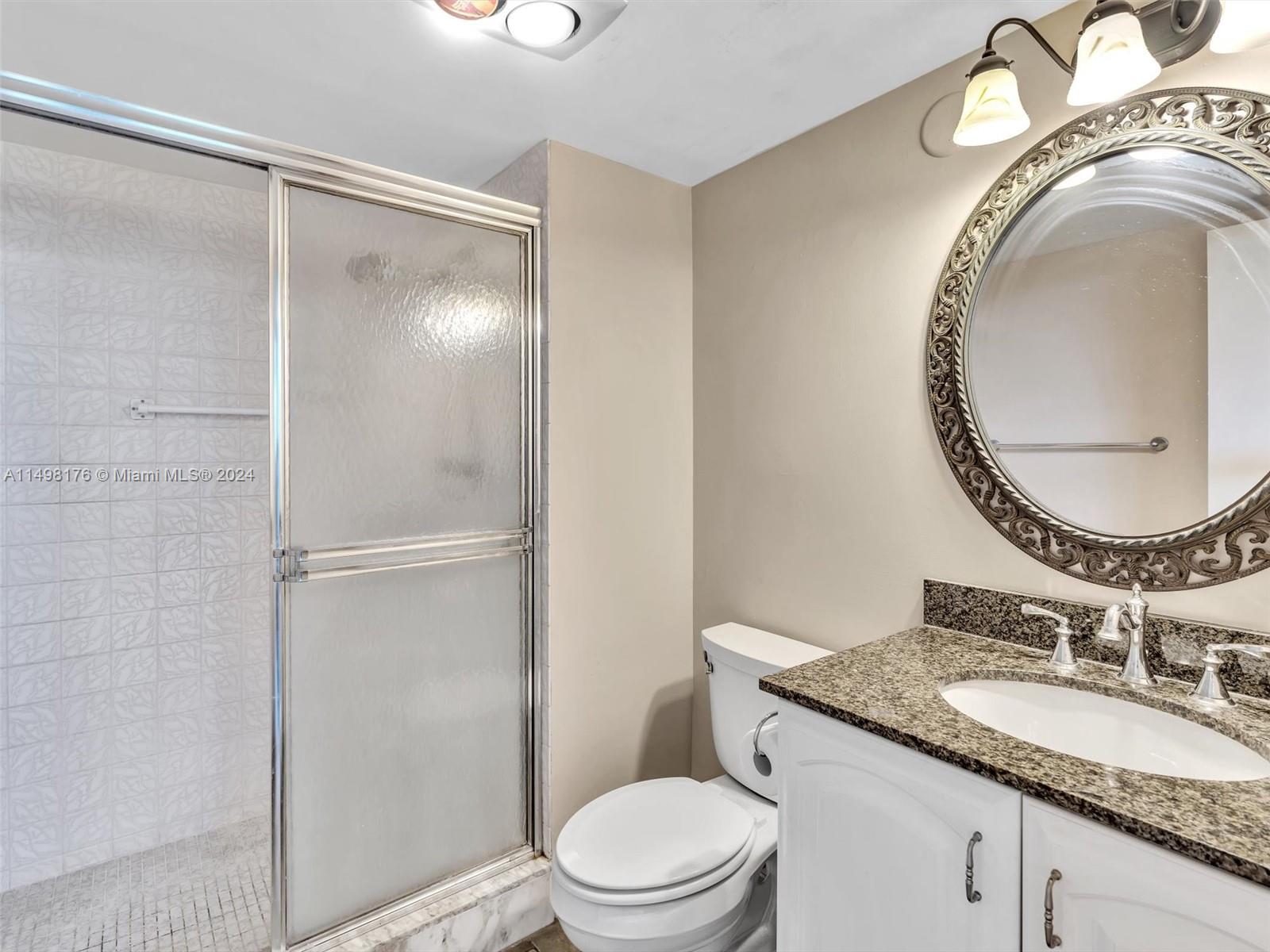 9411 North Hollybrook Lake Drive, Unit 209 Pembroke Pines, FL 33025 - Photo 28 of 36 a bathroom with a granite countertop sink mirror vanity and toilet