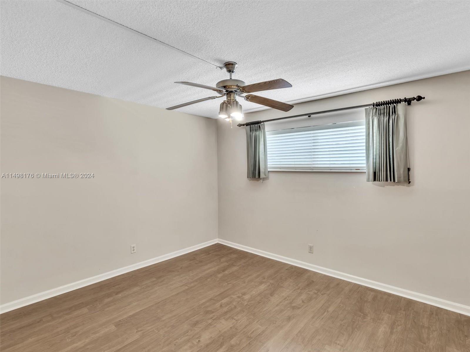 9411 North Hollybrook Lake Drive, Unit 209 Pembroke Pines, FL 33025 - Photo 29 of 36 wooden floor in an empty room with a window