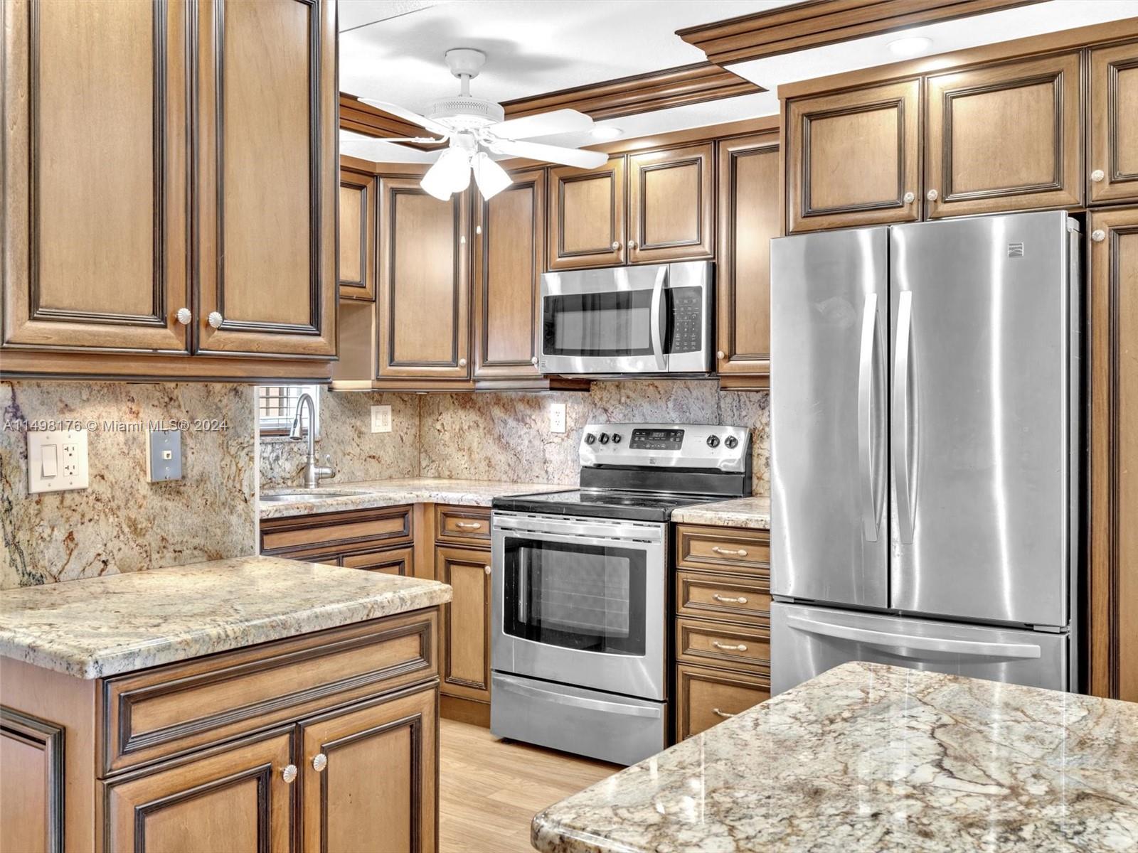 9411 North Hollybrook Lake Drive, Unit 209 Pembroke Pines, FL 33025 - Photo 3 of 36 a kitchen with stainless steel appliances granite countertop a refrigerator stove and sink