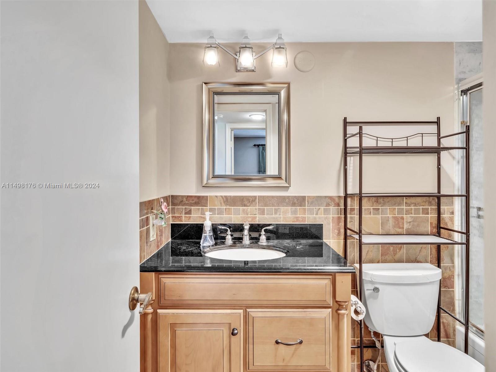 9411 North Hollybrook Lake Drive, Unit 209 Pembroke Pines, FL 33025 - Photo 32 of 36 a bathroom with a toilet sink and mirror