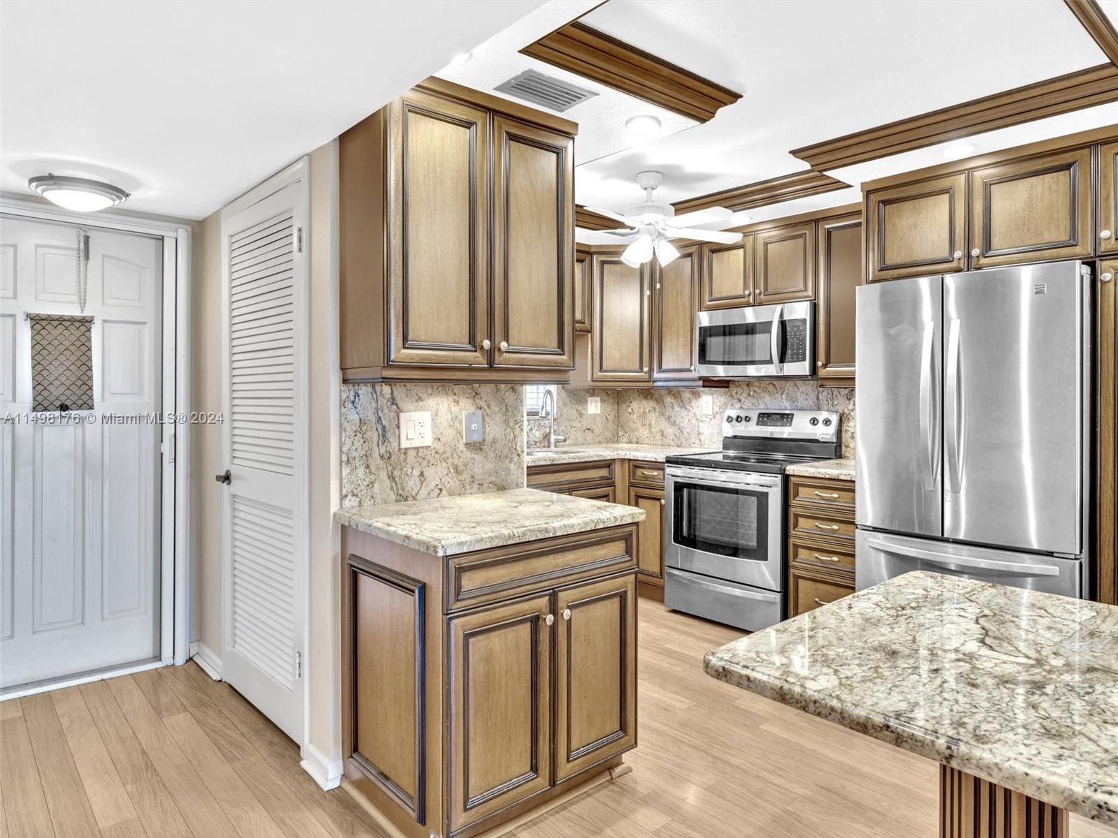 9411 North Hollybrook Lake Drive, Unit 209 Pembroke Pines, FL 33025 - Photo 4 of 36 a kitchen with stainless steel appliances granite countertop a stove a sink and a refrigerator