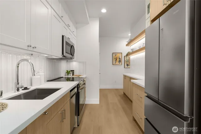 a kitchen with stainless steel appliances granite countertop a sink stove and refrigerator