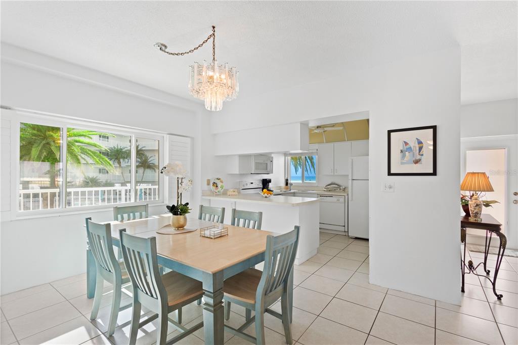 5830 Midnight Pass Road, Unit T22 Sarasota, FL 34242 - Photo 16 of 65 a dining room with furniture a chandelier and window