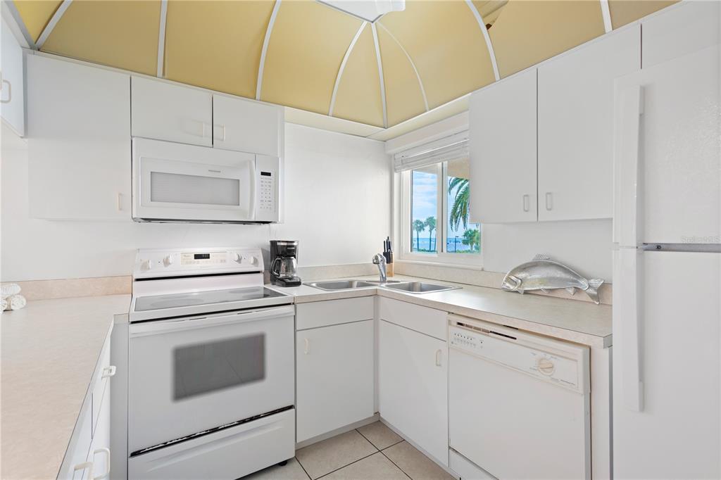 5830 Midnight Pass Road, Unit T22 Sarasota, FL 34242 - Photo 20 of 65 a kitchen with white cabinets and white appliances