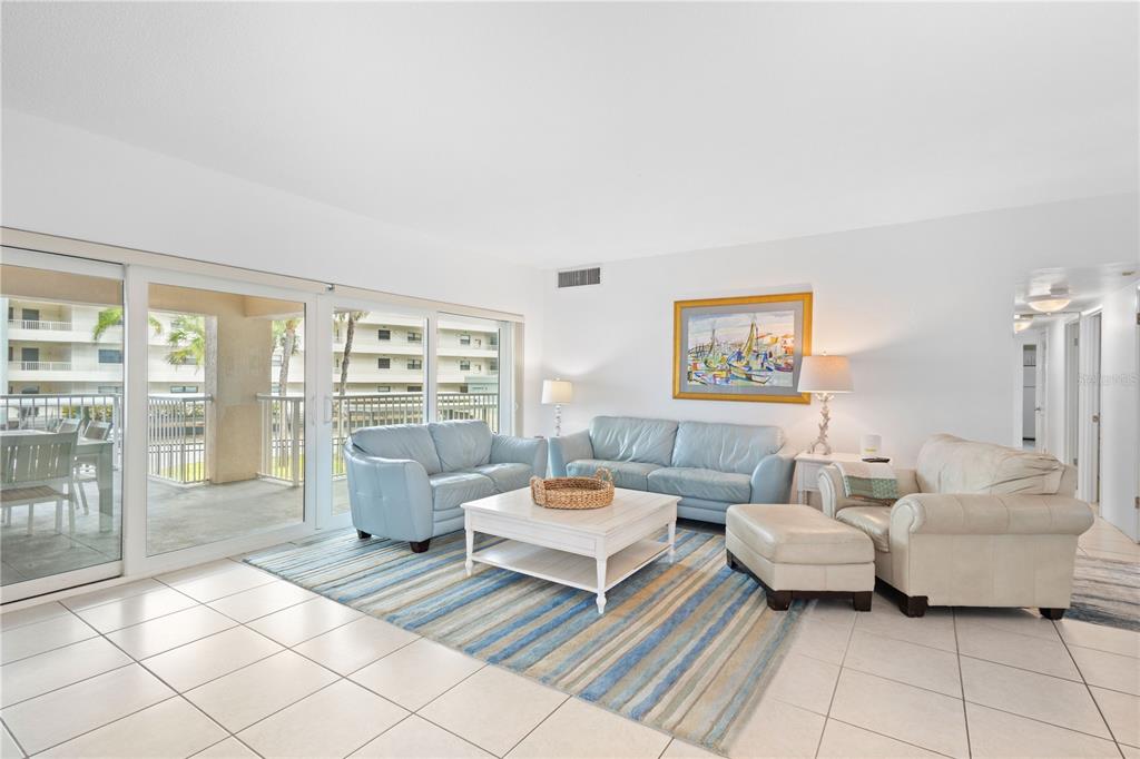 5830 Midnight Pass Road, Unit T22 Sarasota, FL 34242 - Photo 2 of 65 a living room with furniture and a floor to ceiling window