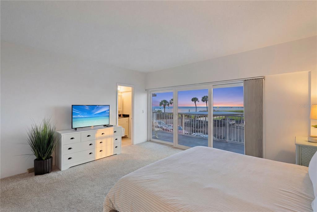 5830 Midnight Pass Road, Unit T22 Sarasota, FL 34242 - Photo 4 of 65 a bedroom with a bed and a painting on the wall