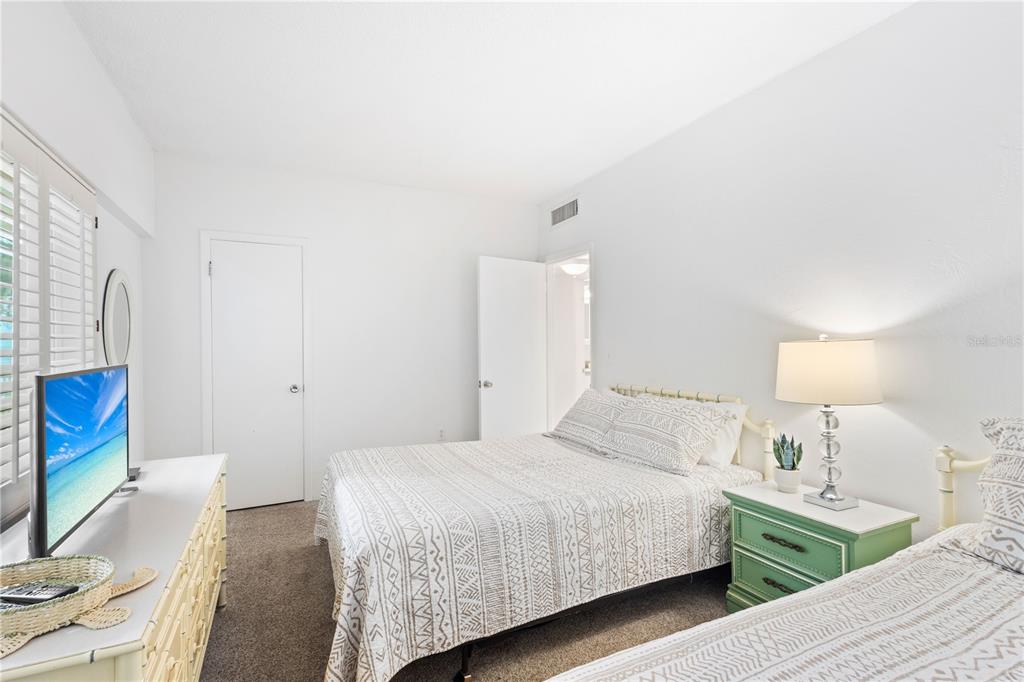 5830 Midnight Pass Road, Unit T22 Sarasota, FL 34242 - Photo 7 of 65 a bedroom with a bed and a flat screen tv
