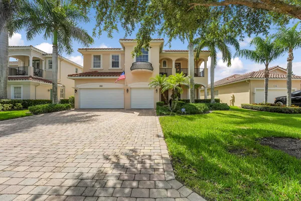 a front view of a house with a yard and palm trees