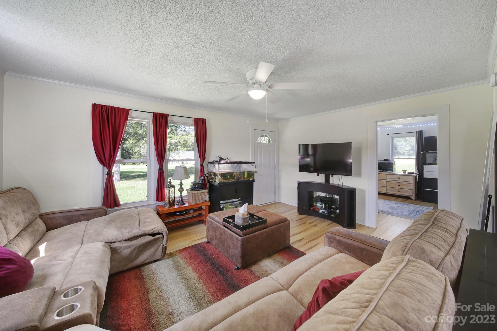 355 Walker Road Mount Pleasant, NC 28124 - Photo 3 of 33 a living room with furniture a flat screen tv and a fireplace