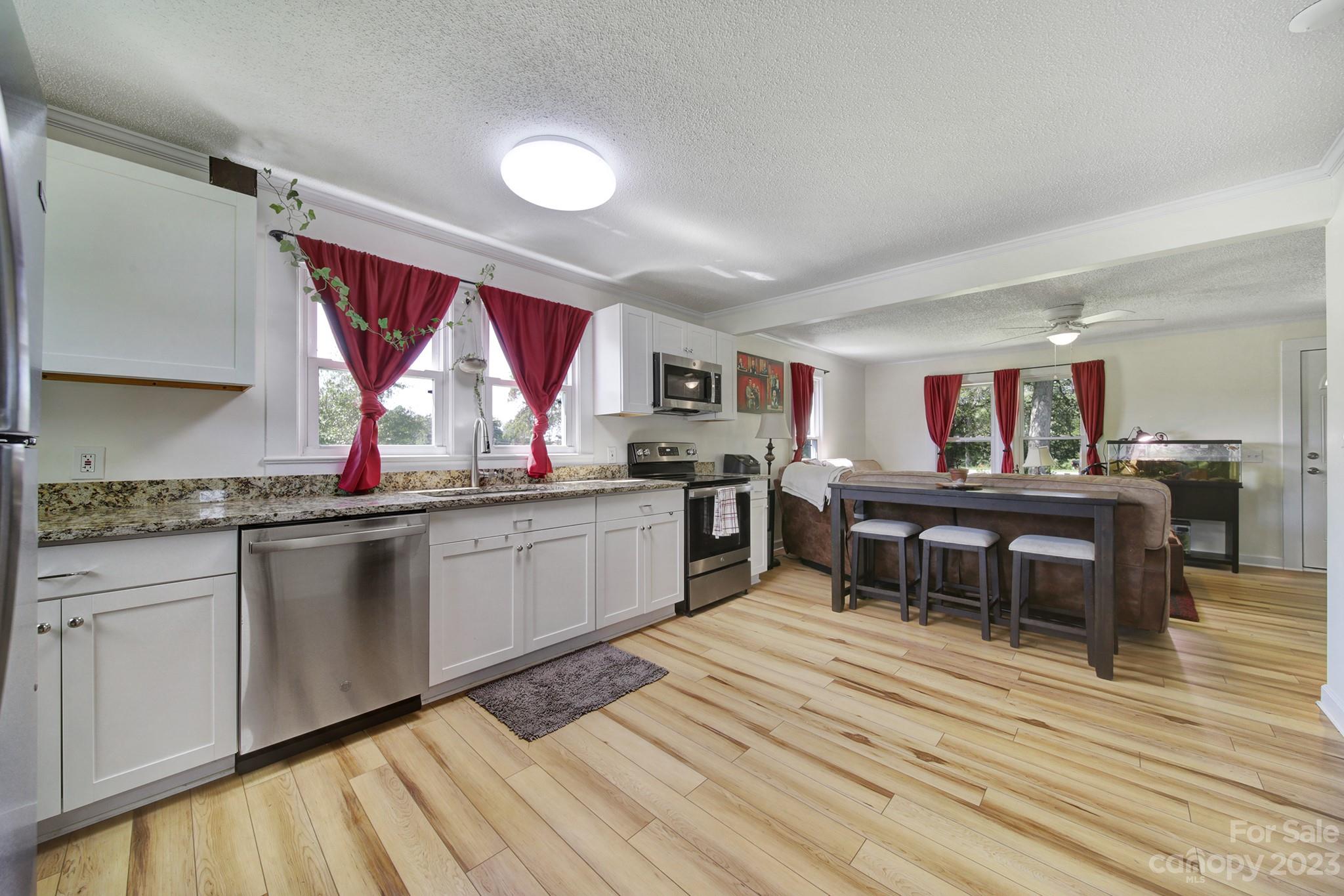 355 Walker Road Mount Pleasant, NC 28124 - Photo 5 of 33 a kitchen with stainless steel appliances granite countertop a kitchen island hardwood floor sink stove dining table and chairs