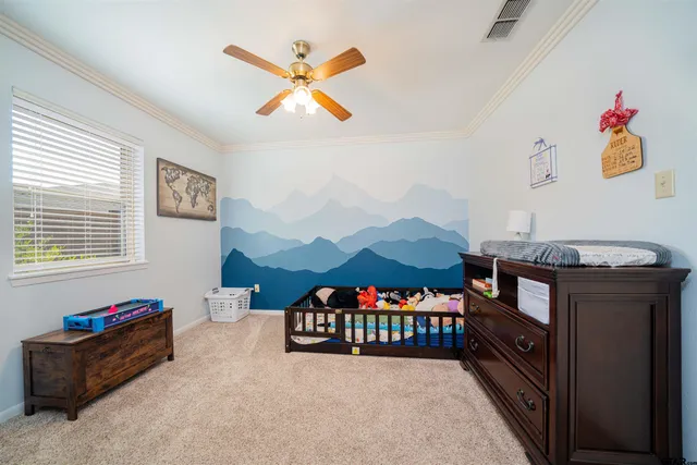 a living room with furniture and a baby crib