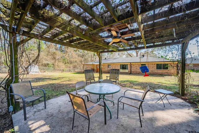 a view of a swimming pool with a patio and a backyard