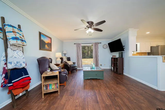 a living room with furniture flat screen tv and wooden floor