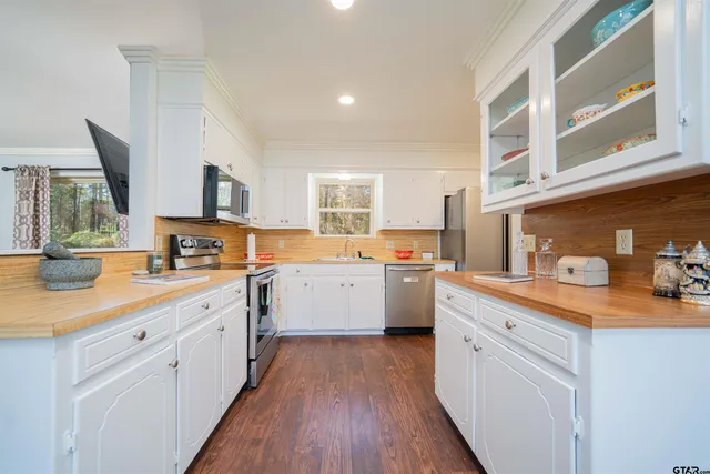 a kitchen that has a lot of cabinets and wooden floor